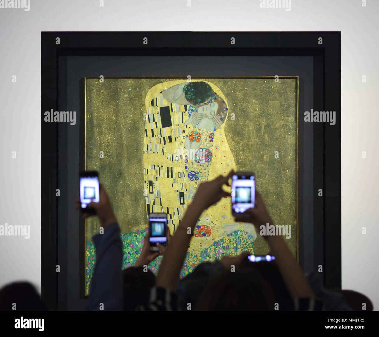 Visitors use smartphones to photograph the famous painting 'The Kiss' (1907-1908) by Austrian symbolist painter Gustav Klimt displayed in the Belvedere Museum in Vienna, Austria. Stock Photo