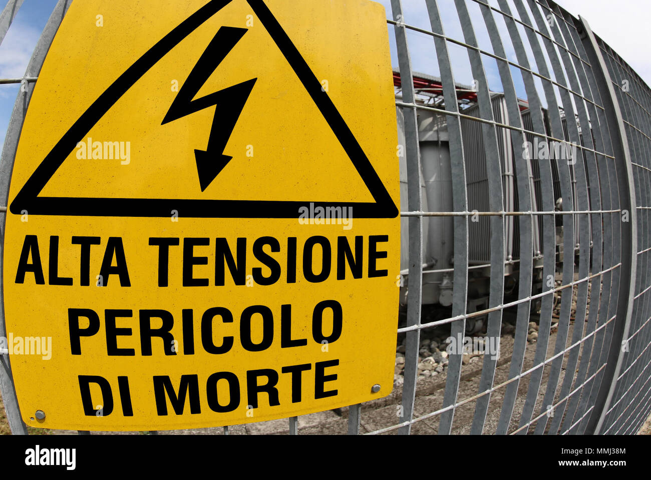 big yellow signboard in the power station with text that means HIGH VOLTAGE MORTAL DANGER Stock Photo