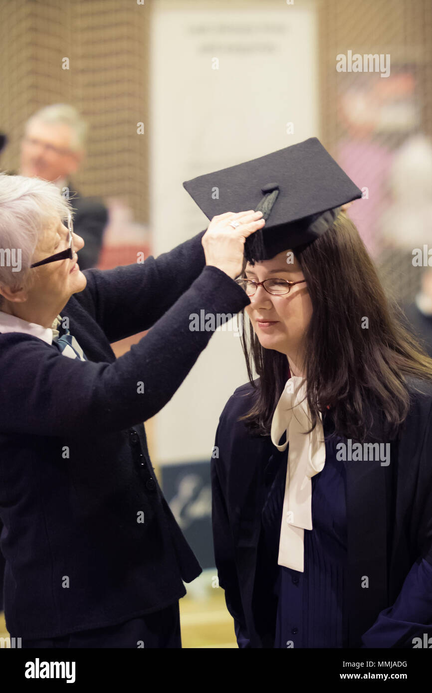 Caucasian Female Mature Graduate Being Dressed in Cap & Gown (Mortarboard) in Preparation for Masters Degree Graduation Ceremony University of Chester Stock Photo