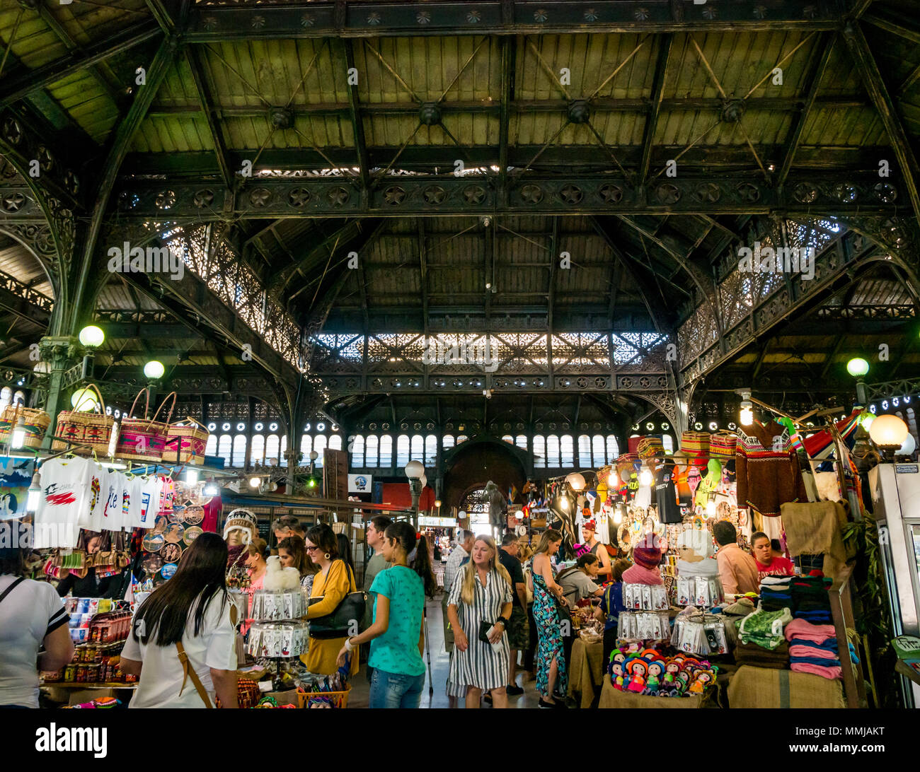 People browsing stalls in historic old Central Market building, Santiago, Chile, with ornate ironwork roof Stock Photo