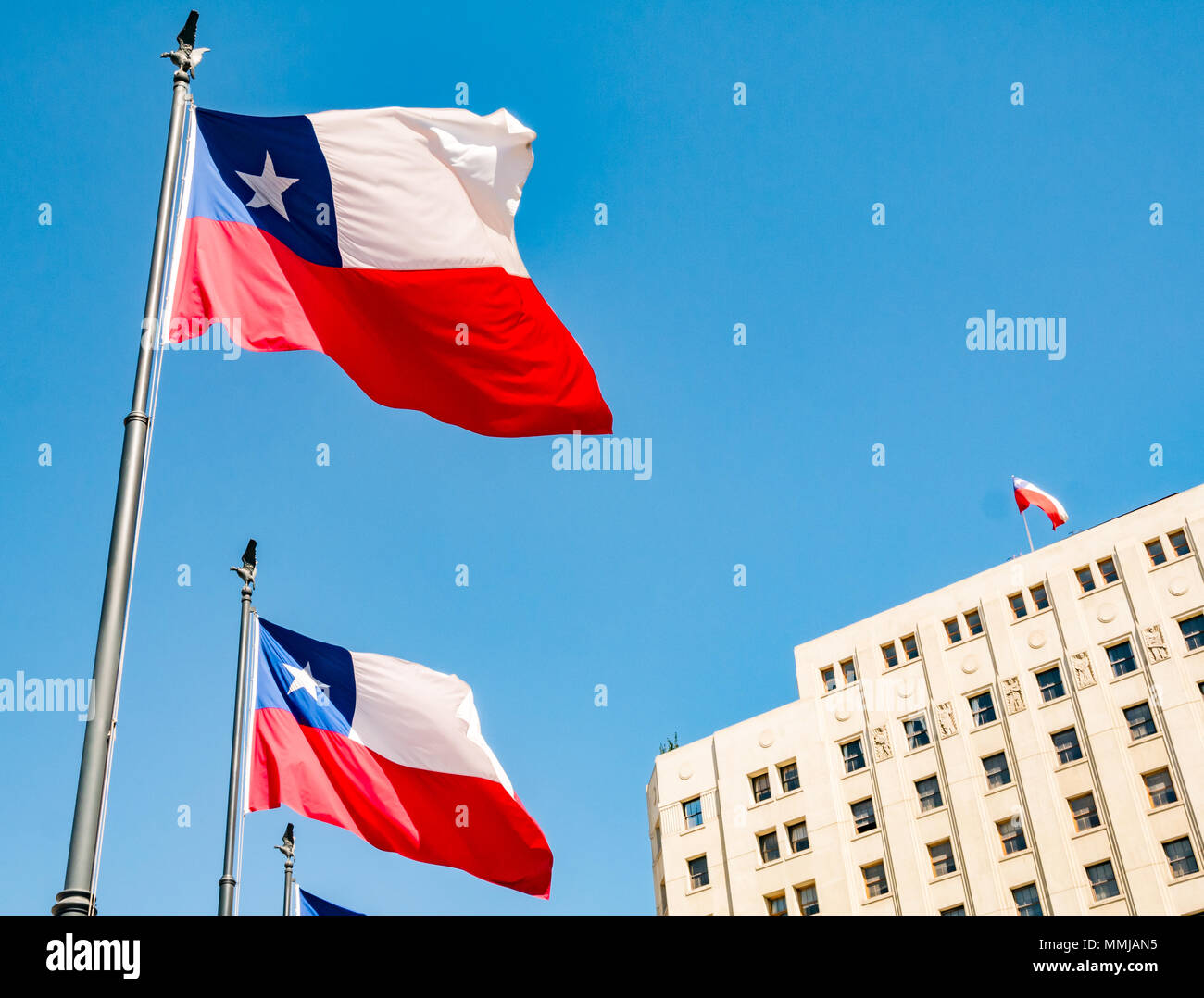 Chilean flags flying against blue sky outside Internal Revenue Service of Chile, Santiago, Chile Stock Photo