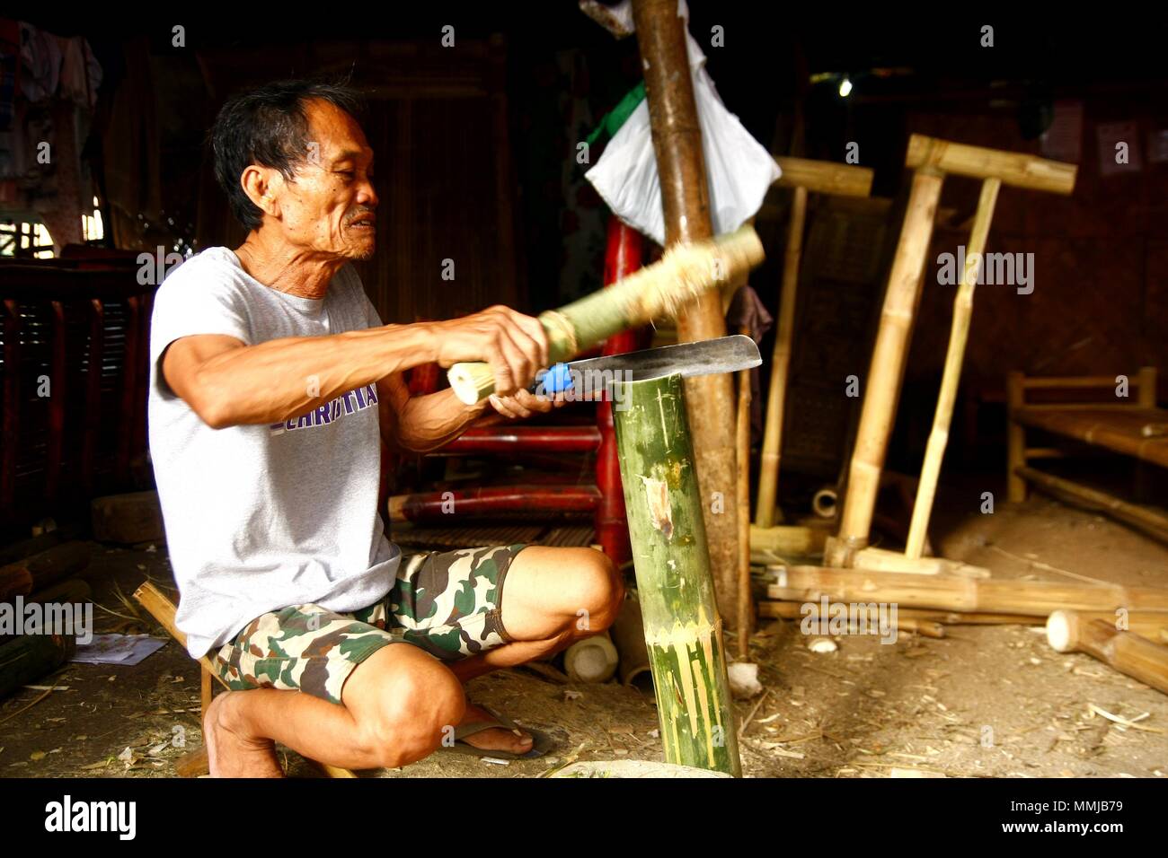 ANTIPOLO CITY, PHILIPPINES - MAY 1, 2018: A carpenter cuts bamboo which he will make into a home furniture. Stock Photo