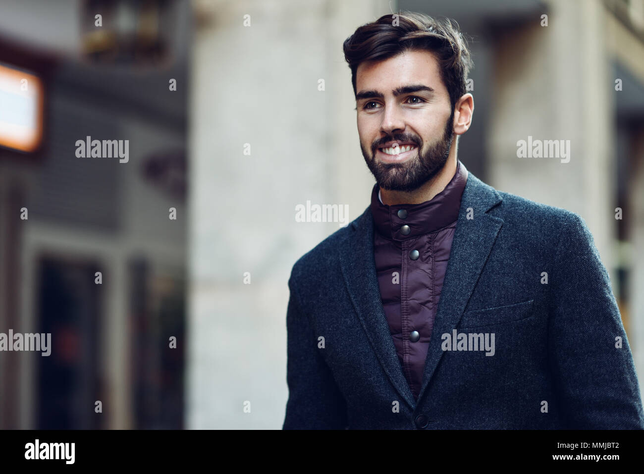 Young bearded smiling man, model of fashion, in urban background wearing  british elegant suit. Guy with beard and modern hairstyle in the street  Stock Photo - Alamy