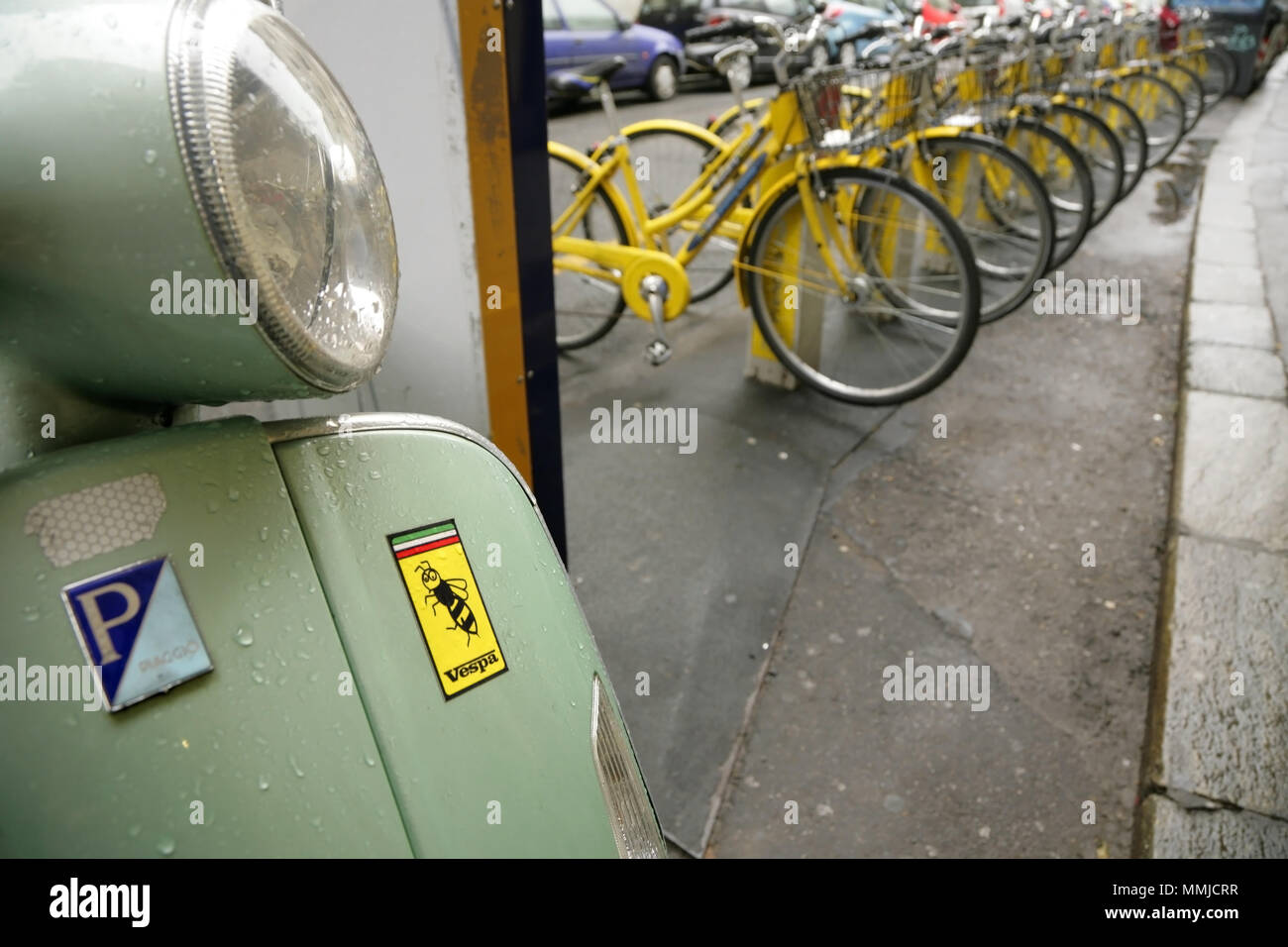 Green Vespa Piaggio motor scooter and bicycles for hire, Turin, Italy. Stock Photo