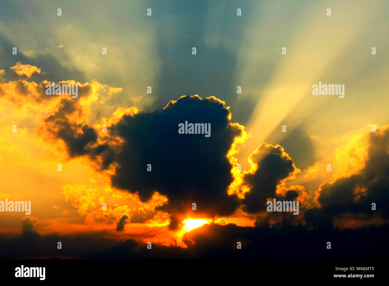 Beautiful sunset with sunbeam, sunray through the clouds. Magneficient moments. Stock Photo