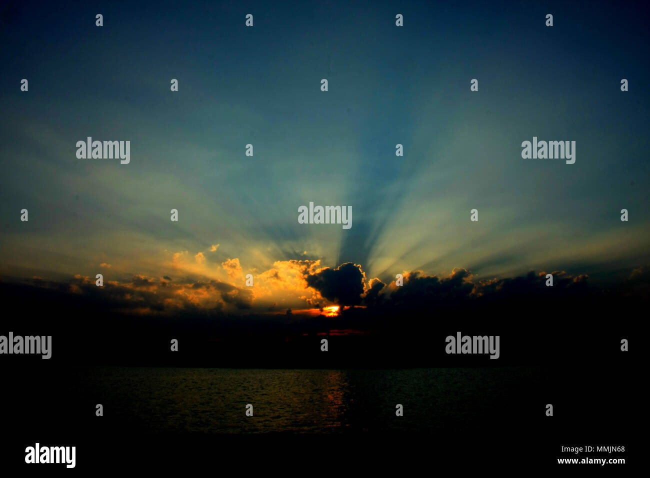Beautiful sunset with sunbeam, sunray through the clouds. Magneficient moments. Stock Photo