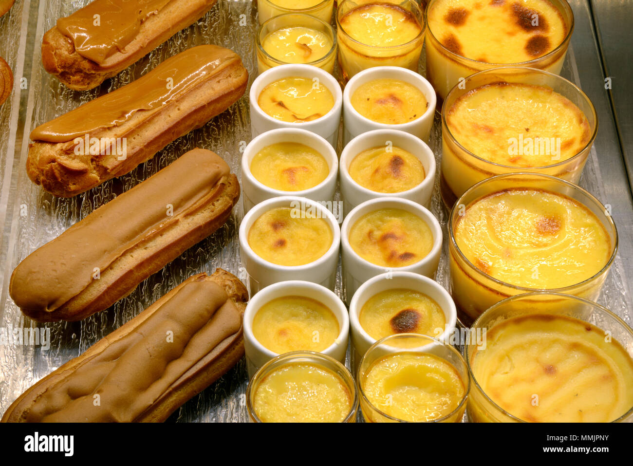 Display of Crèmes Caramels & Coffee Eclairs Pastries or Cakes in a French Patisserie France Stock Photo
