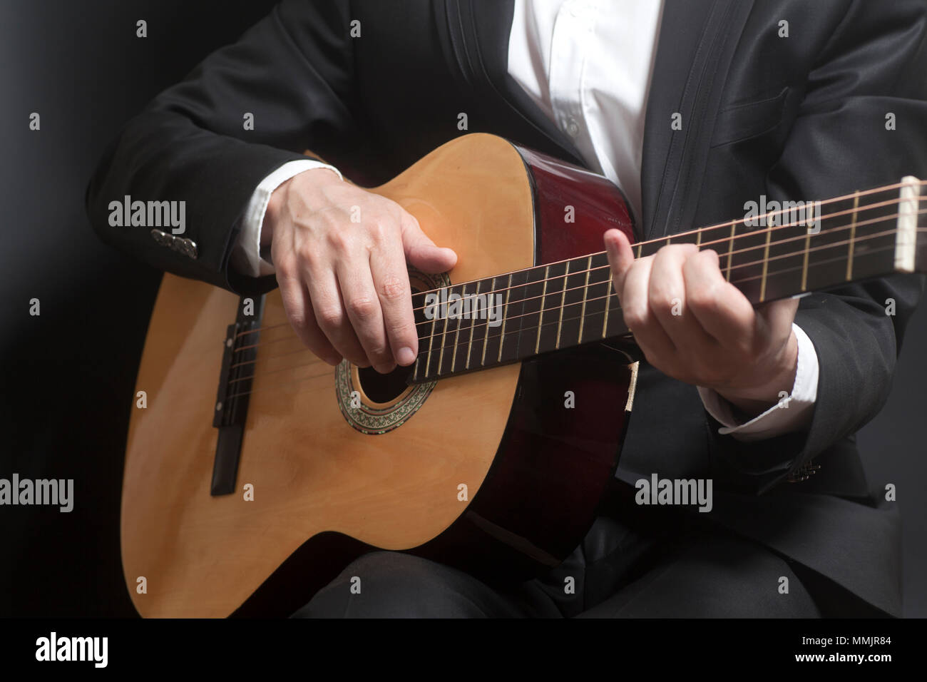 Man in black suit with acoustic classic guitar close up Stock Photo - Alamy