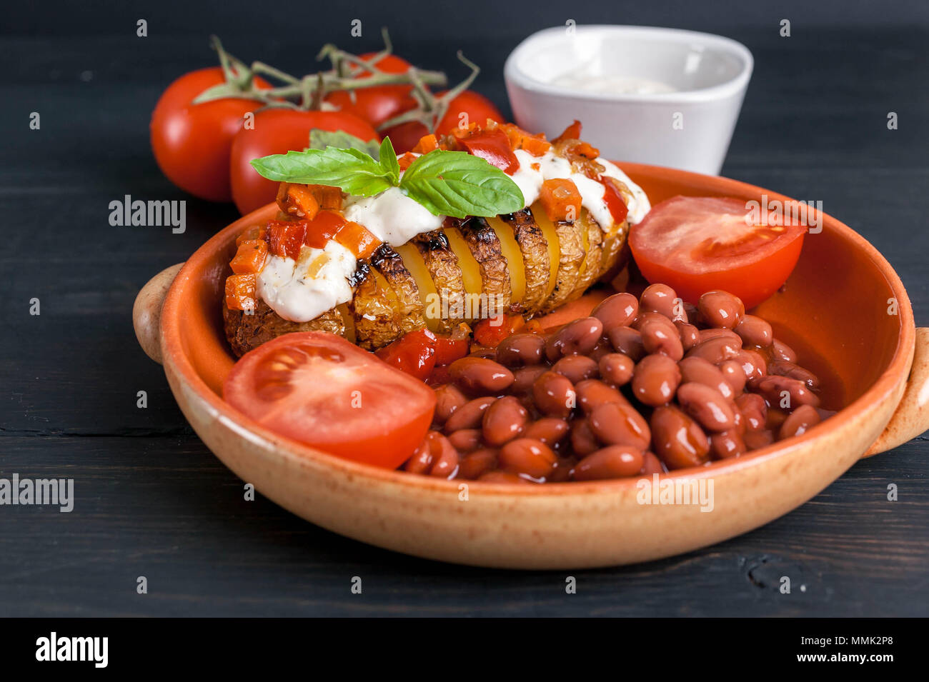 Baked potatoes with mozzarella cheese and vegetables, with stewed beans