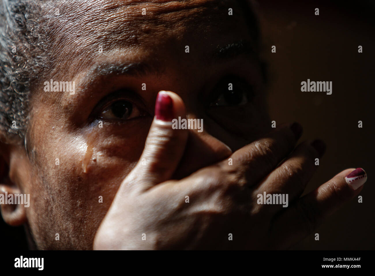 01 May 2018, Brazil, Rio de Janeiro: Marcia de Oliveira Silva Jacintho crying as she speaks about her son, Hanry Silva Gomes Ciqueira. Hanry died on 21 November 2002 during a police raid in the Lins favela, where he used to live with his mother. Two police officers were accused of intentional killing and found guilty. Marcia is still awaiting for the compensation promised to her. Photo: Diego Herculano/dpa Stock Photo