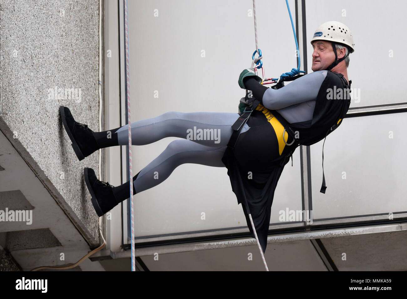 Volunteers are abseiling down the side of Southend Hospital’s 154ft tower block to raise money for charities, with a focus on wards and departments of the hospital. Batman costume Stock Photo