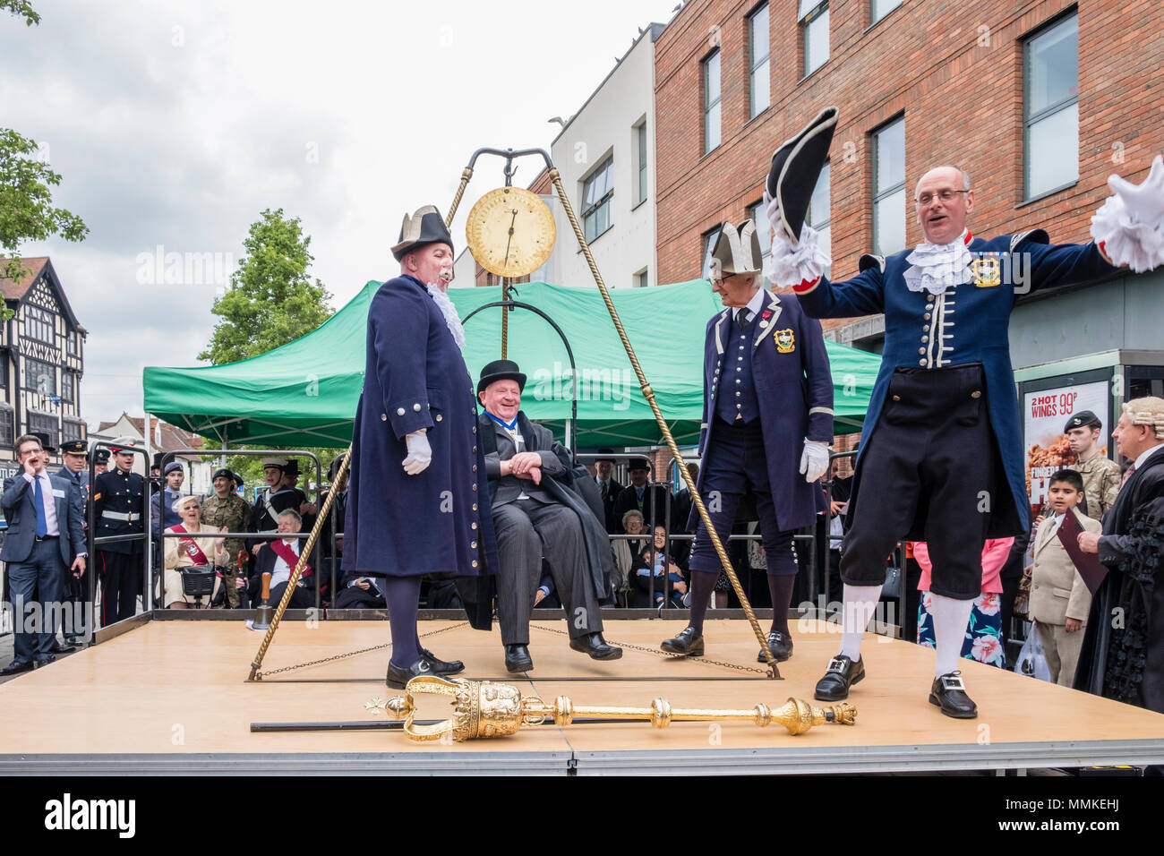 Saturday May 12th 2018. High Wycombe, Buckinghamshire, England, GB, UK. The quaint local tradition of 'Weighing in the Mayor' took place in the town centre today.  Traditionally, the outgoing and incoming mayor and civic officials are weighed at the beginning of the mayor's term of office each year to ascertain if they have gained weight at the expense of the taxpayer. The outgoing mayor, Brian Pearce is shown on the scales. Credit: D. Callcut/Alamy Live News Stock Photo