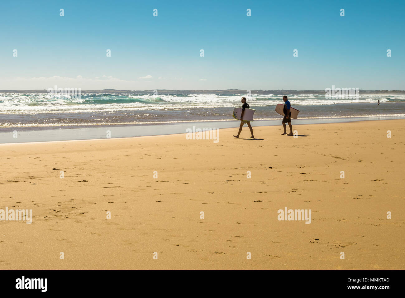 Phillip Island, Victoria, Australia - January 4, 2015: Two surfers holding surfboards at Woolamai Beach, Cape Woolamai State Faunal Reserve in summer Stock Photo
