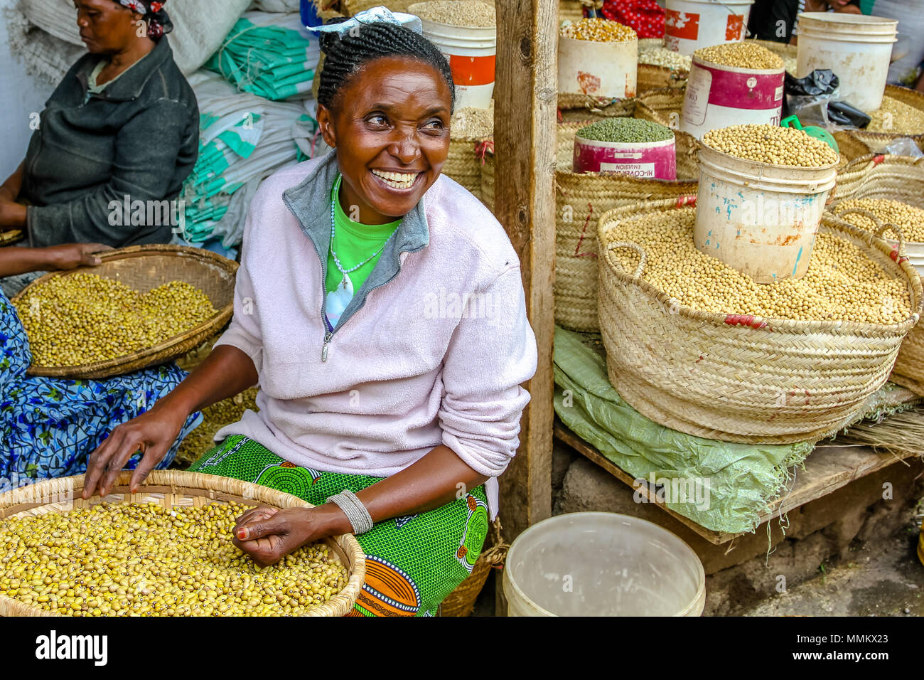 Arusha, Tanzania, Africa - January 2, 2013: Happy woman selling cereals at famous town market of Arusha Stock Photo