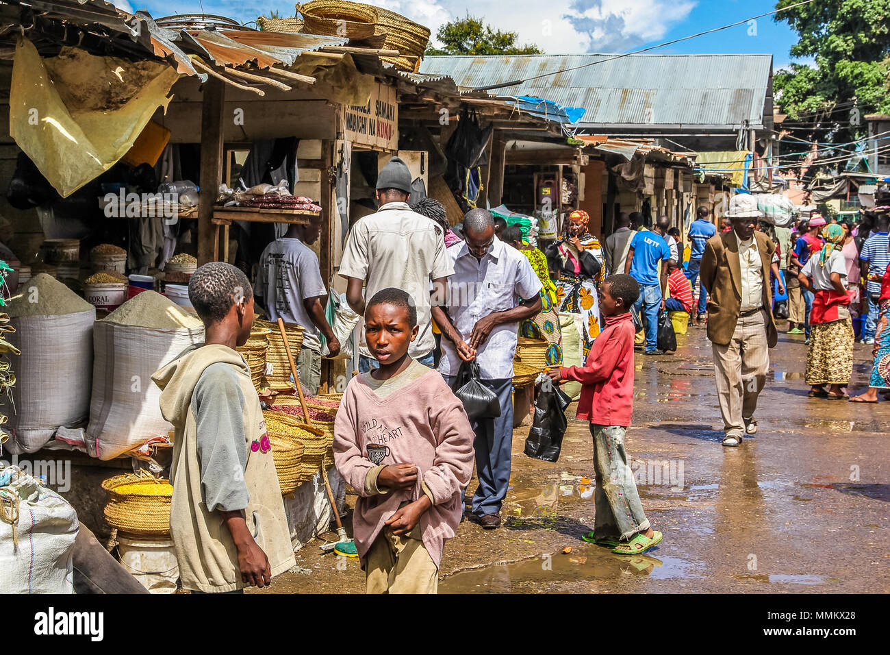 Arusha, Tanzania, Africa - January 2, 2013: Children on the road in a market of the town. These african markets are full of colors and people selling their local products and their own cultivated fruits and vegetables Stock Photo