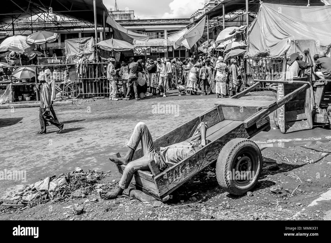 Arusha, Tanzania, Africa - January 2, 2013: Man lying on a wooden cart sleeps at the market in town Stock Photo