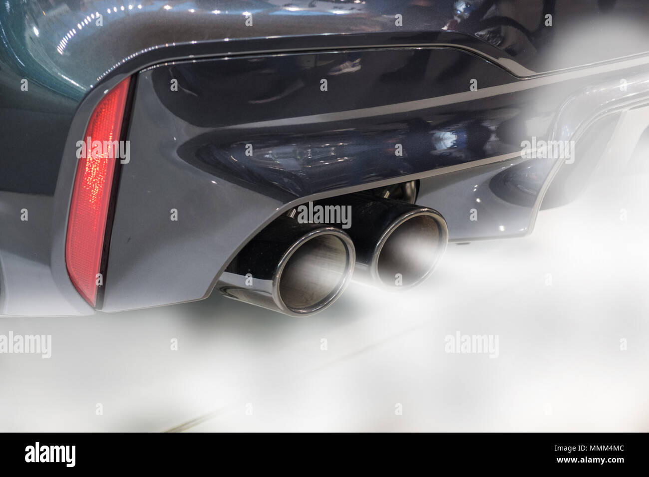 Dual exhaust pipe close up with combustion fumes coming out Stock Photo