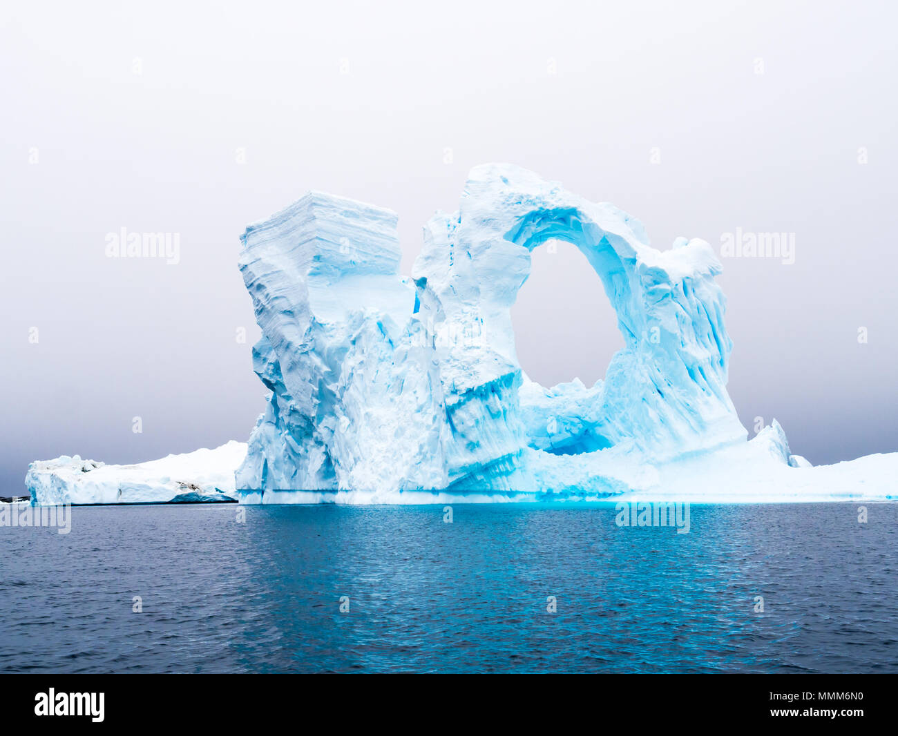 Arch shaped iceberg aground in Pleneau Bay as part of iceberg graveyard, south of Lemaire Channel west of Antarctic Peninsula, Antarctica Stock Photo