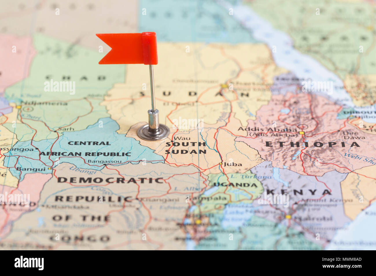 Small red flag marking the African country of  South Sudan on a world map. Stock Photo