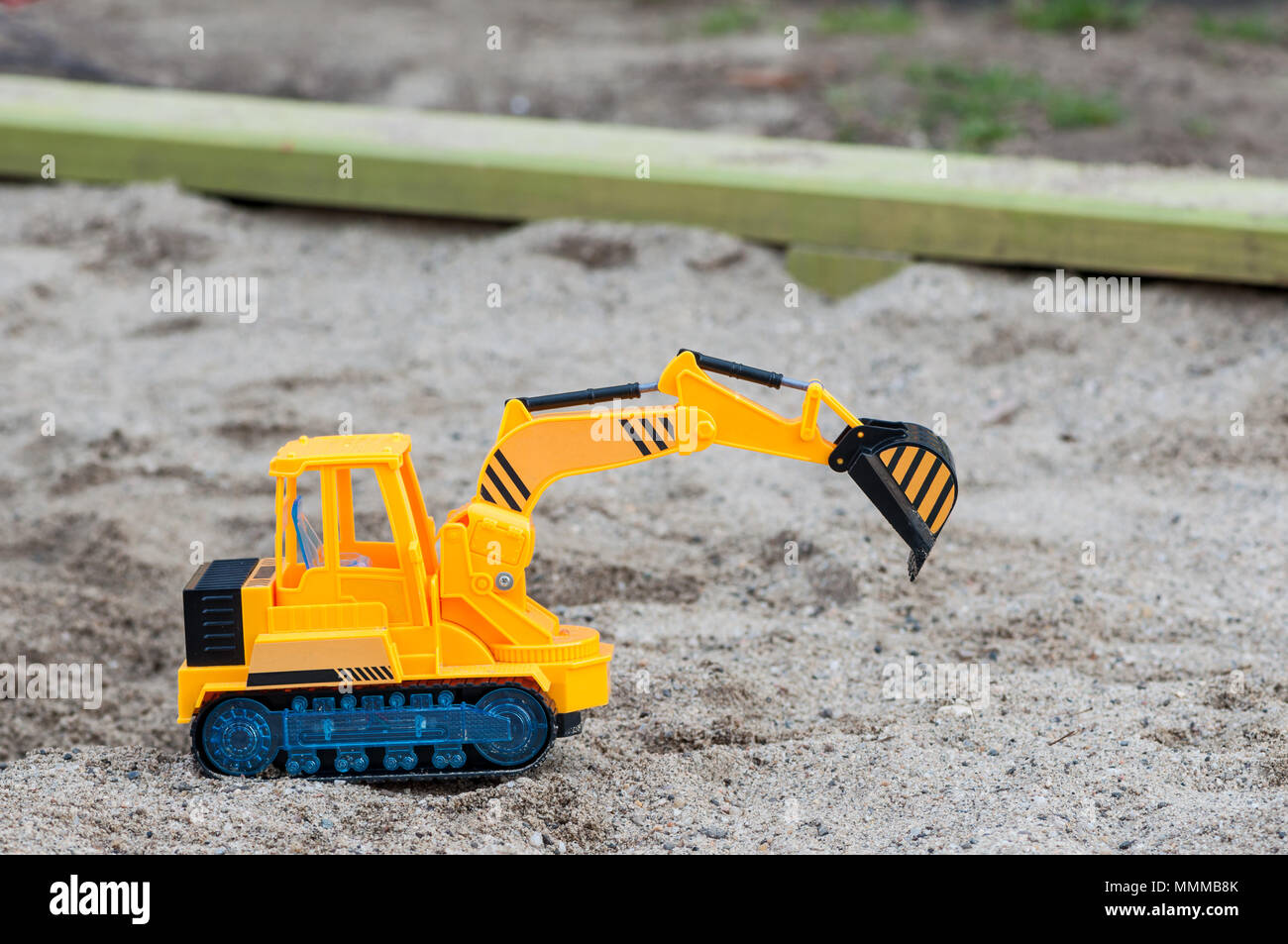 Plastic toy excavator in the sand. Children's toy. Childhood memories