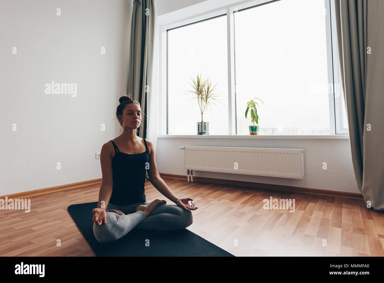 Young woman meditating indoors. A series of yoga poses. lifestyle concept Stock Photo
