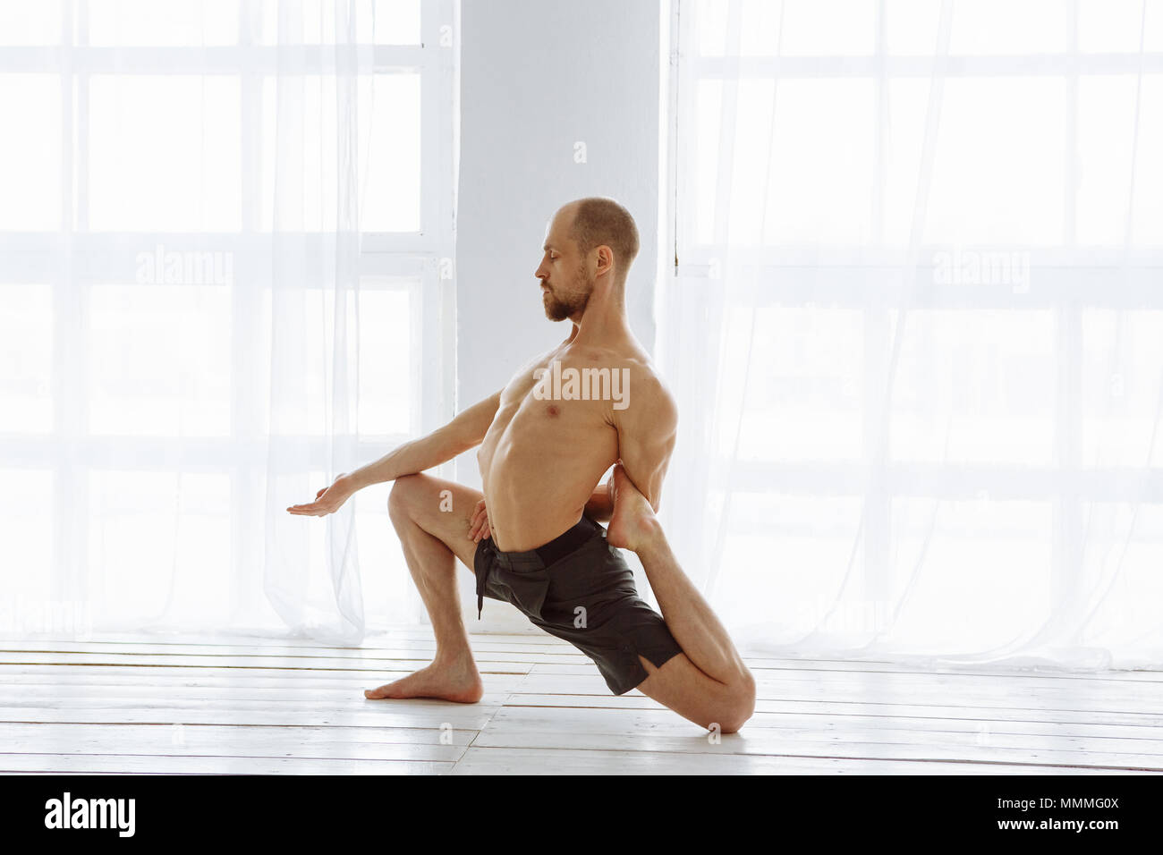 Professional male yoga instructor correcting chair position Stock