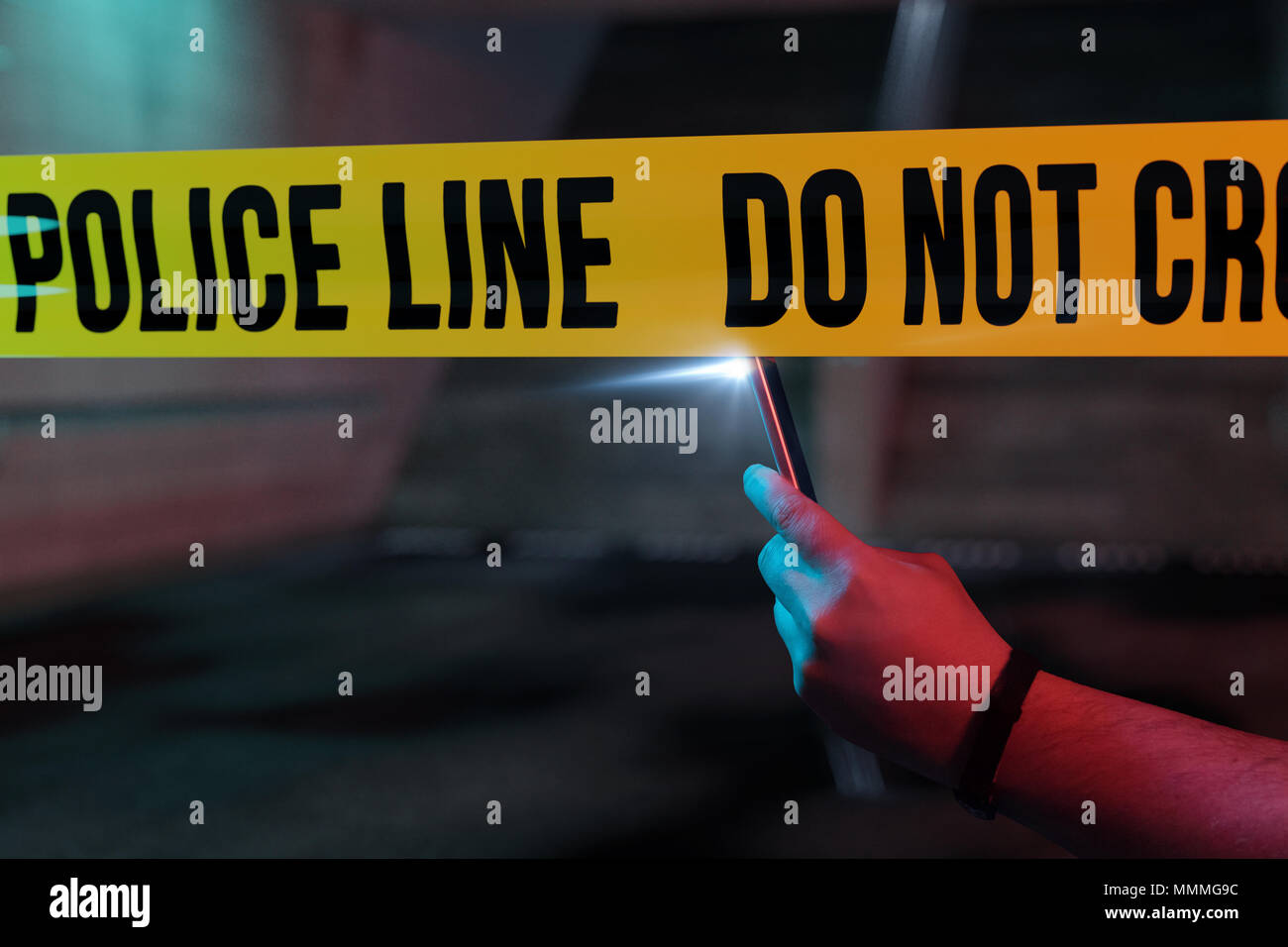 curious onlooker taking picture with smartphone the crime scene at night Stock Photo