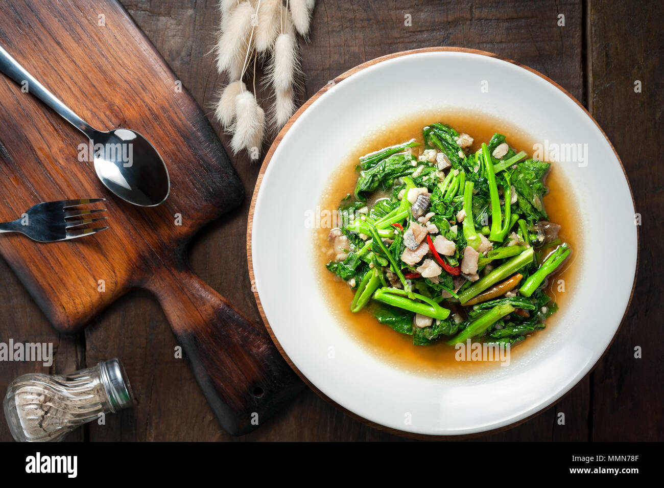 Thai food Stirfried kale with sundried salted fish on wooden table