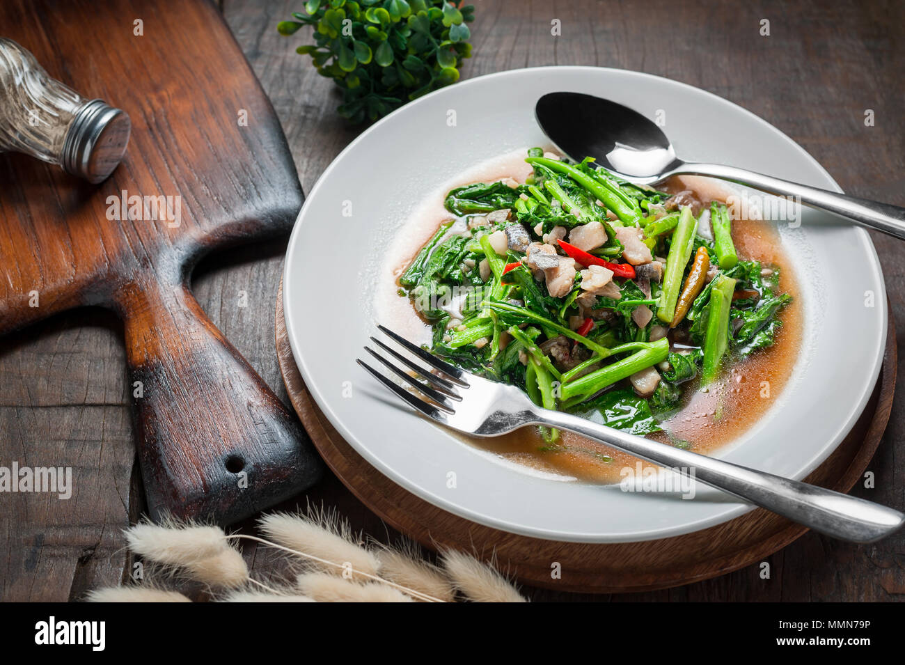 Thai food Stirfried kale with sundried salted fish on wooden table