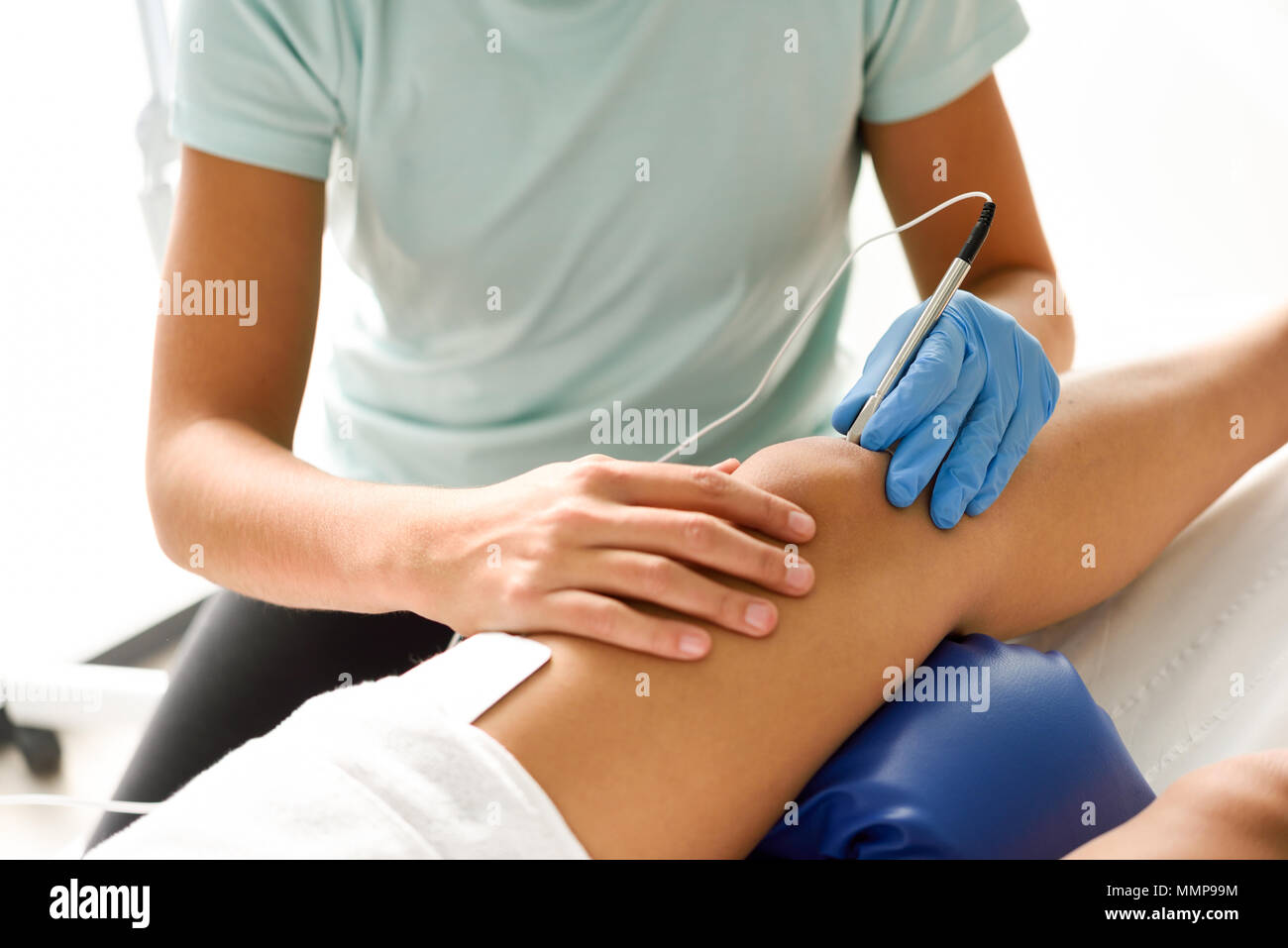Electroacupuncture dry with needle connecting machine used by acupunturist on female patient for acupuncture guided by EPI Intratissue Percutaneous El Stock Photo