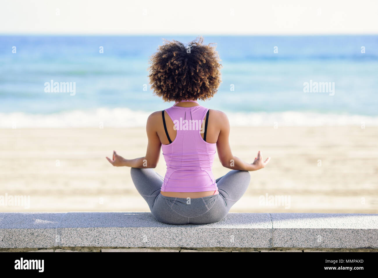 Rear View Of Black Woman Afro Hairstyle Doing Yoga In The Beach