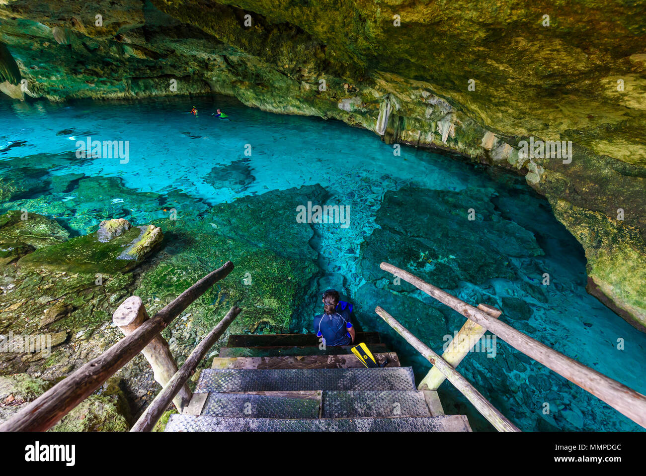 Cenote Dos Ojos in Quintana Roo, Mexico. People swimming and snorkeling in clear blue water