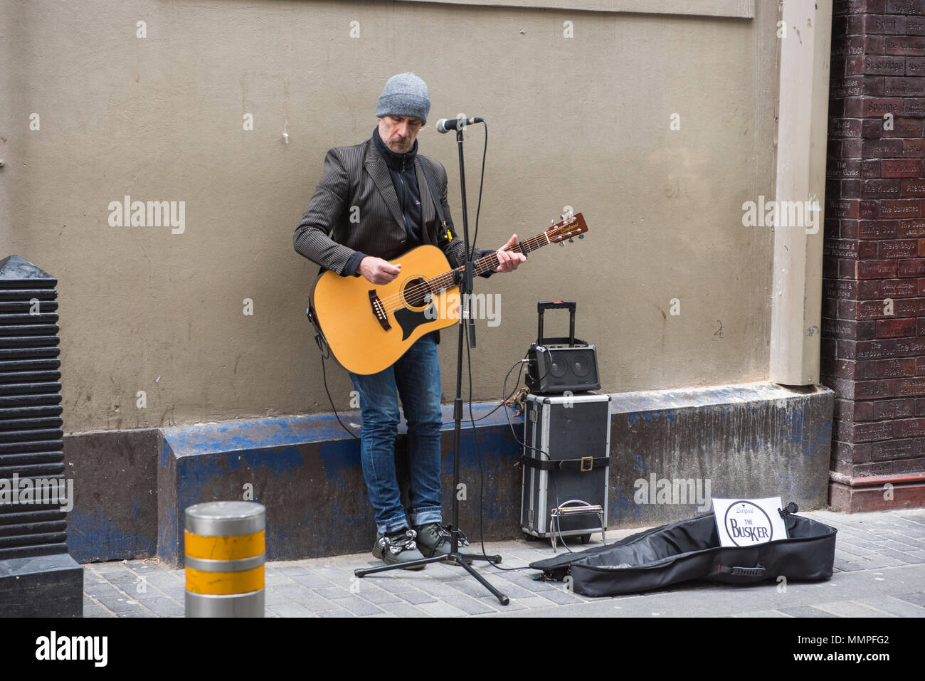 A male busker with a guitar and a speaker Stock Photo - Alamy