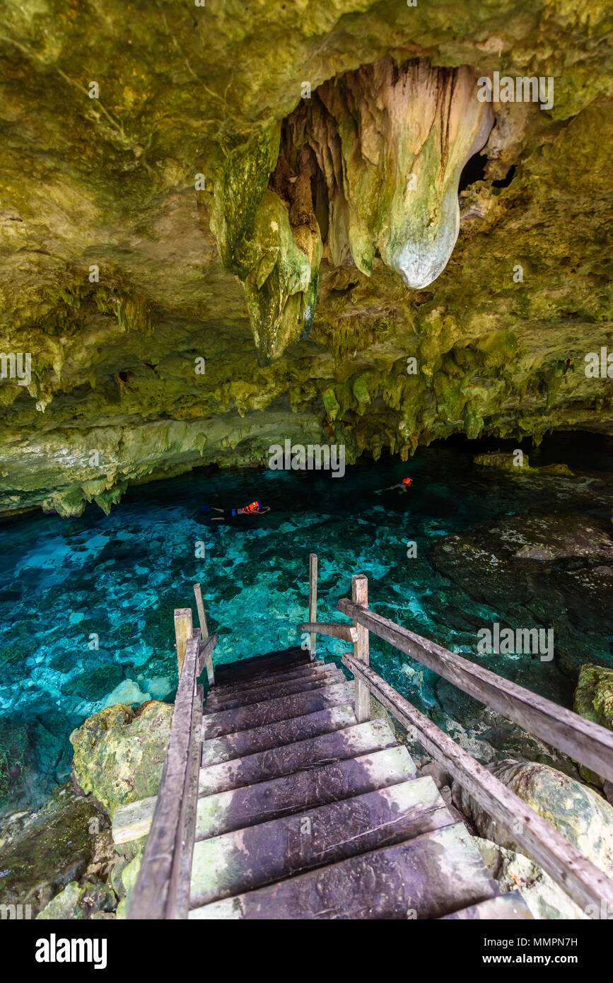 Cenote Dos Ojos in Quintana Roo, Mexico. People swimming and snorkeling in clear water. This