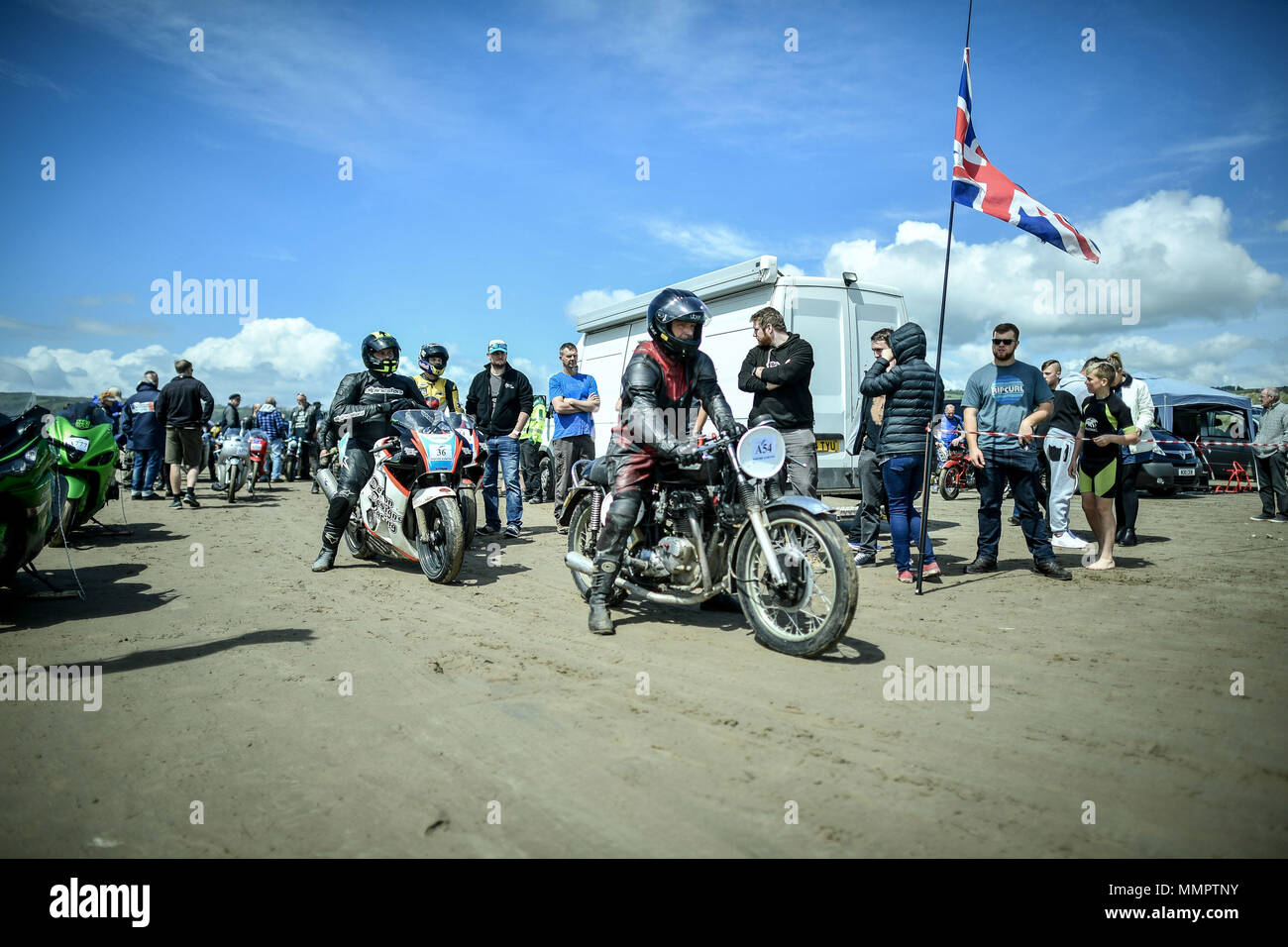 Competitors on motorbikes wait to take part in the annual UK, European and World land speed event organised by Straightliners, at Pendine Sands, Wales, where riders and drivers of all vehicle types compete in classes for top speeds over a measured mile on the beach. Stock Photo