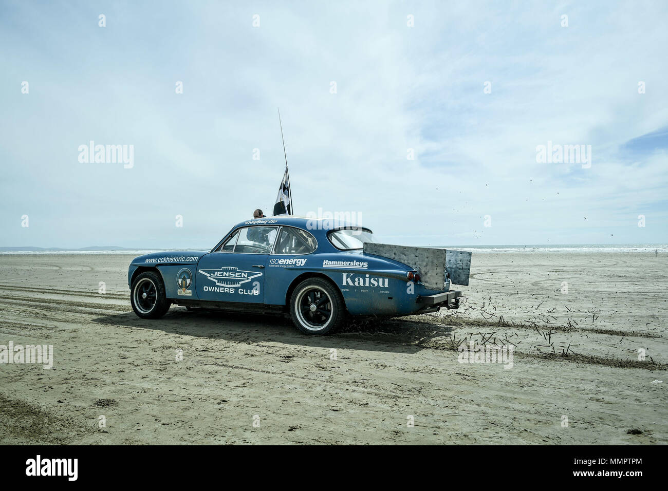 A Jensen sports car pulls away as it takes part in the annual UK, European and World land speed event organised by Straightliners, at Pendine Sands, Wales, where riders and drivers of all vehicle types compete in classes for top speeds over a measured mile on the beach. Stock Photo