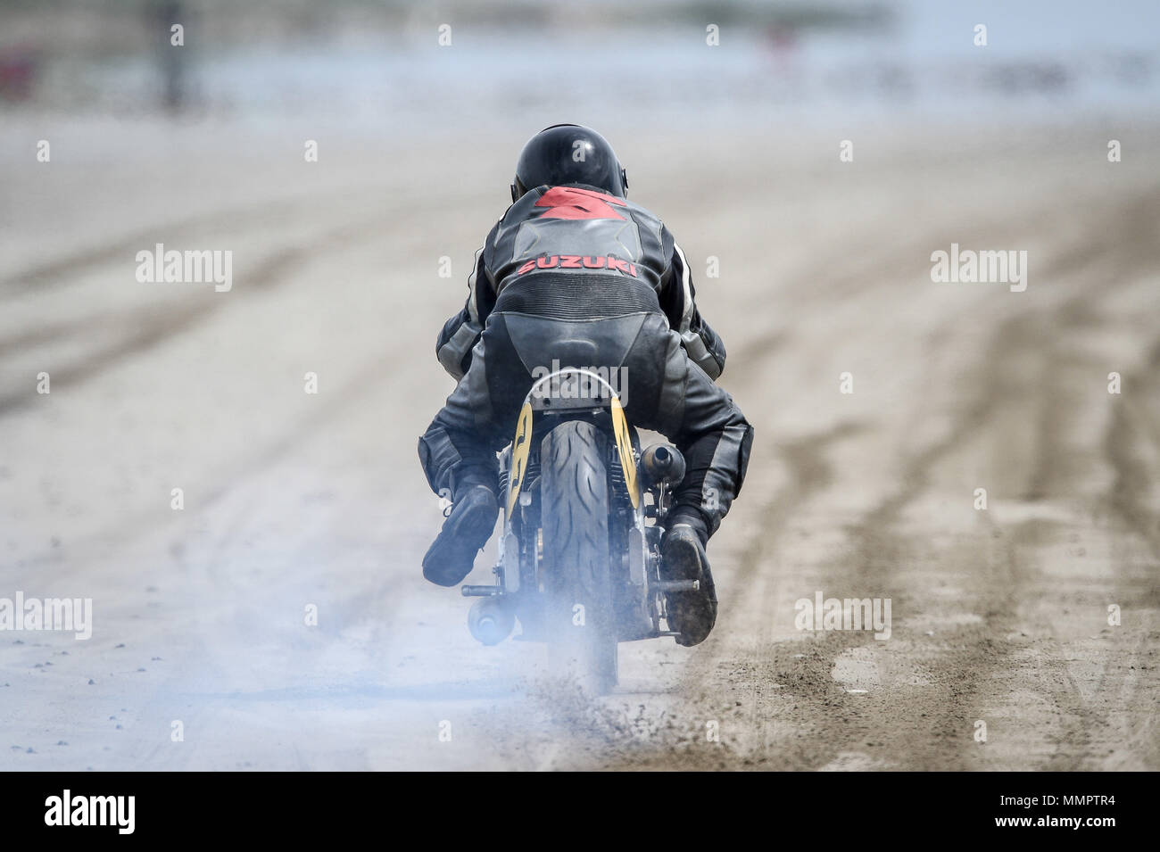 A competitor on motorbike takes part in the annual UK, European and World land speed event organised by Straightliners, at Pendine Sands, Wales, where riders and drivers of all vehicle types compete in classes for top speeds over a measured mile on the beach. Stock Photo