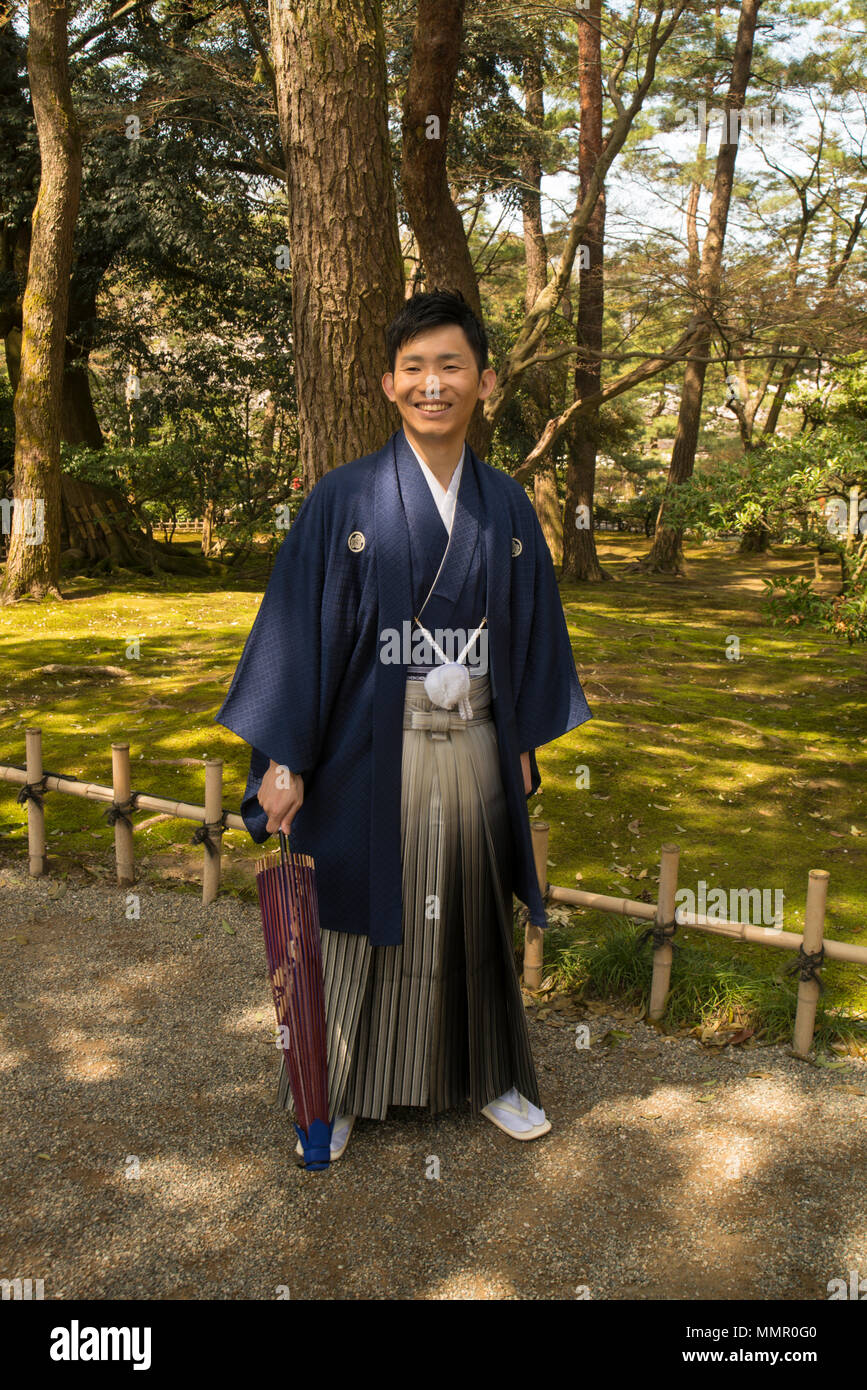 Waiting for wedding photos with umbrella at hand in Kenroku-en Gardens, Japan Stock Photo