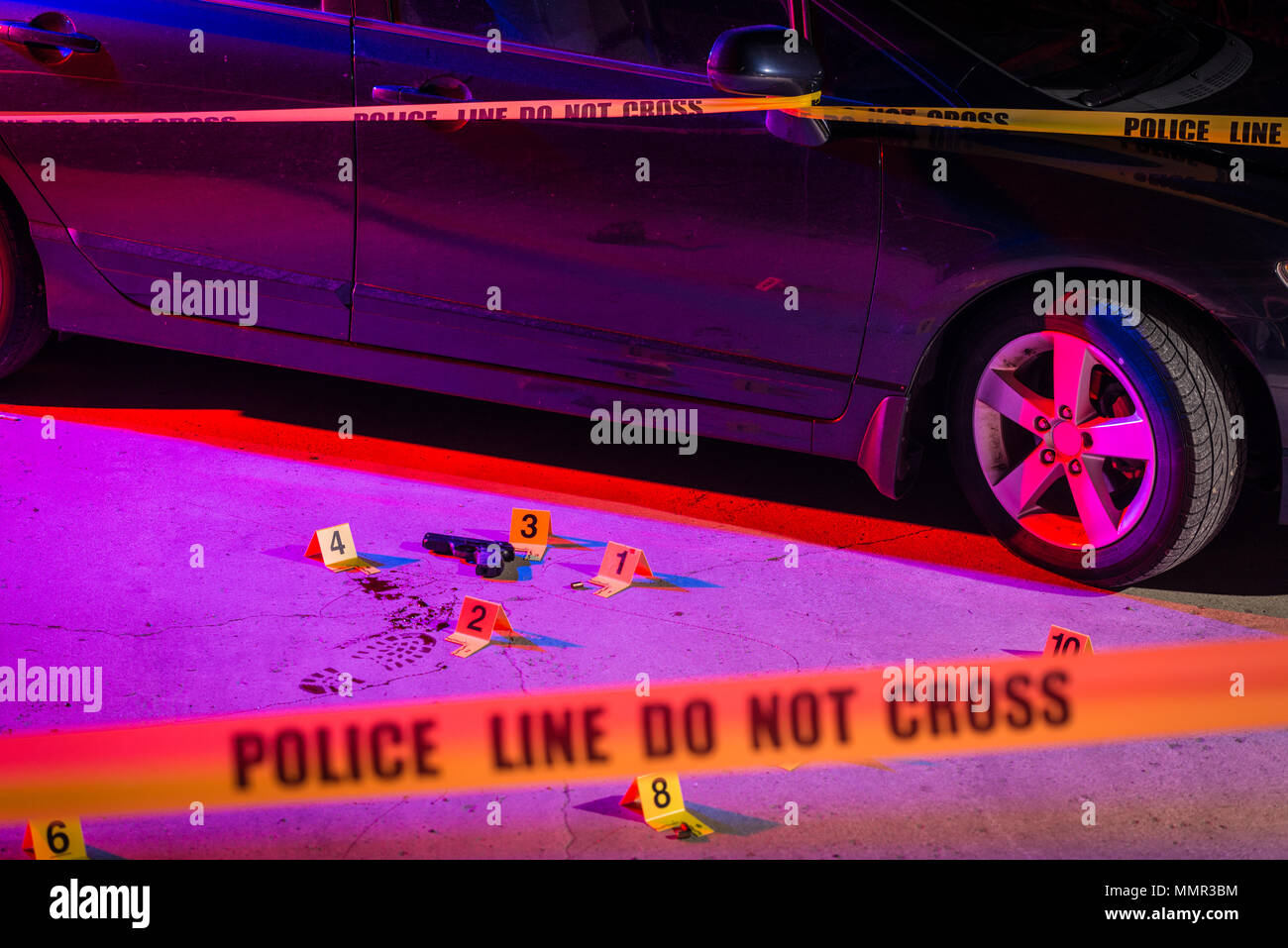 Evidence is marked with evidence markers within a crime scene. Cordon tape can be seen in the foreground. Stock Photo