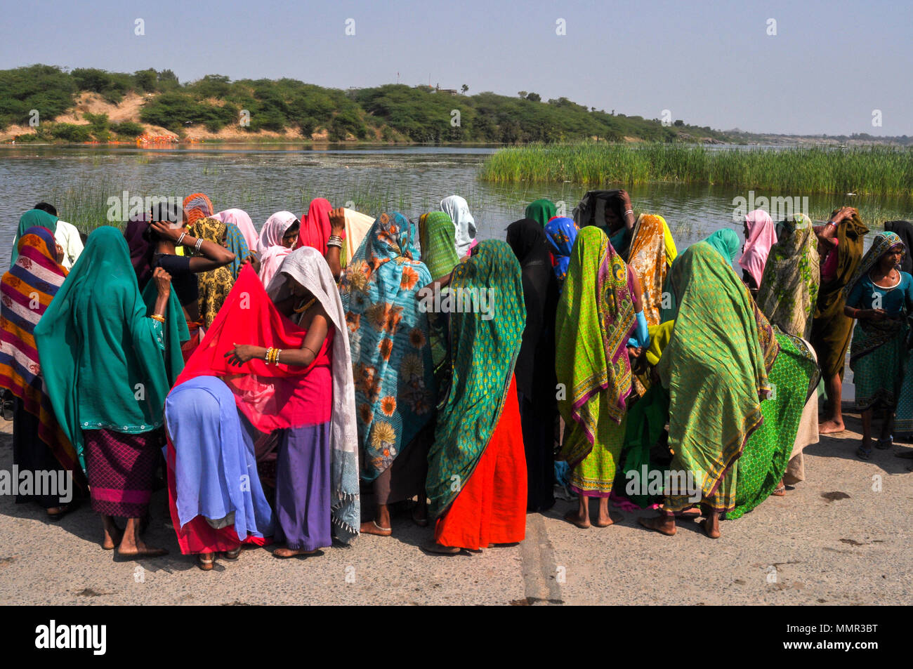 Baneshwar, Dungarpur, Rajasthan, India- February 14, 2011: Bhil women in brightly coloured veils and saris enjoying panoramic view of the fair ground Stock Photo