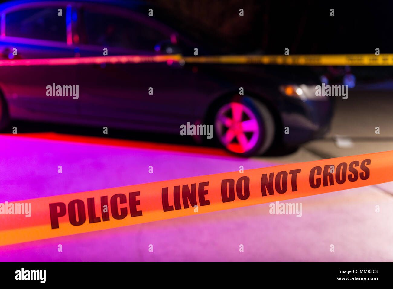 Cordon tape, marking a police line, is stretched in front of a crime scene. Stock Photo
