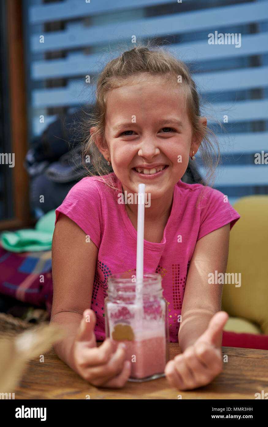 little girl drinking a cocktail in a cafe Stock Photo