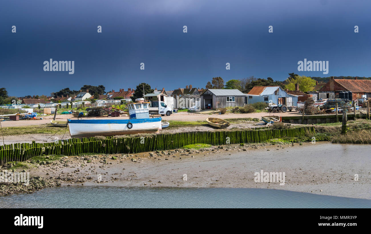 The fishermans hard at Brancaster Staithe as a spring shower passes by. Stock Photo