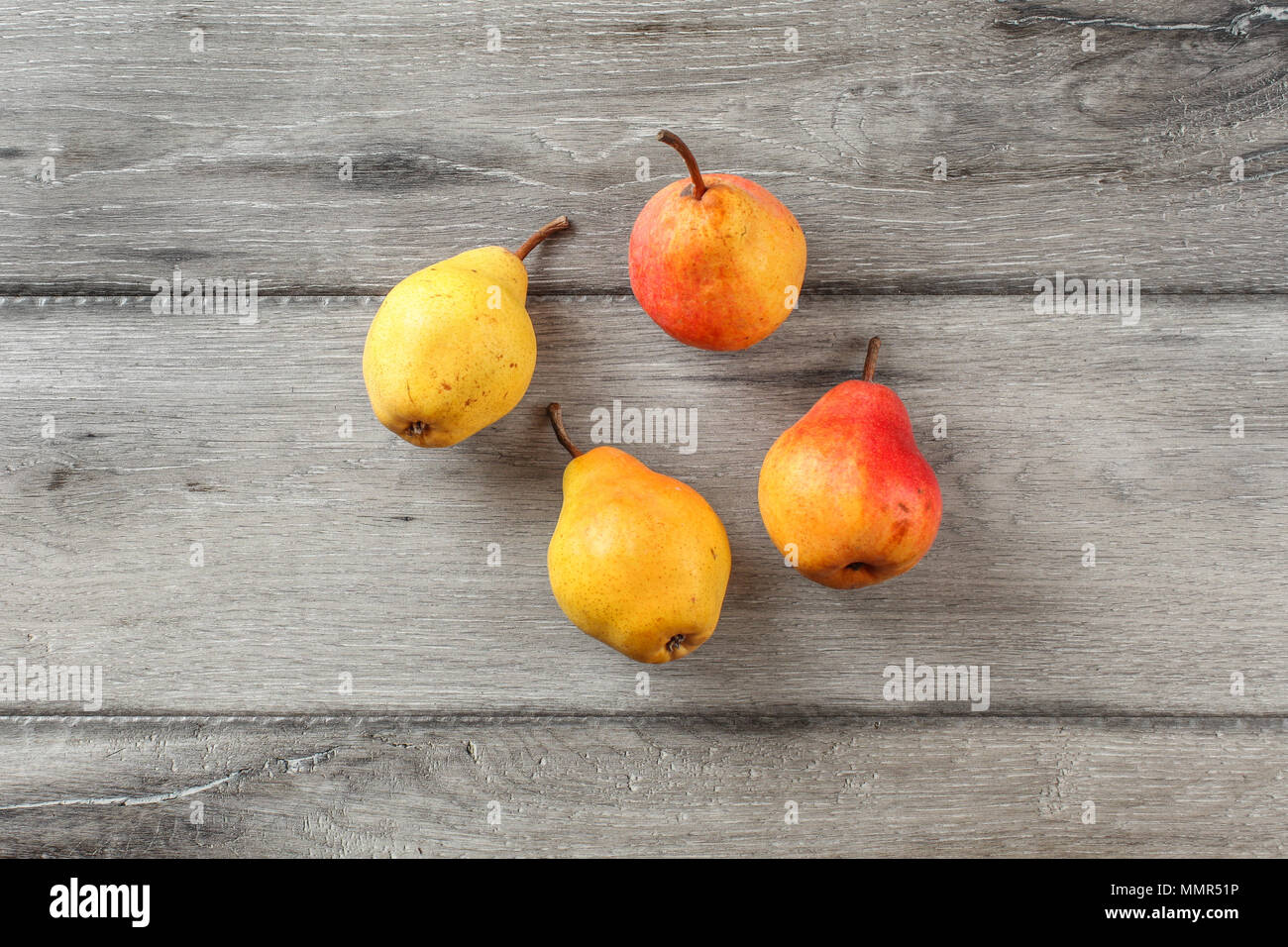Table top view on four ripe pears on gray wood desk. Stock Photo