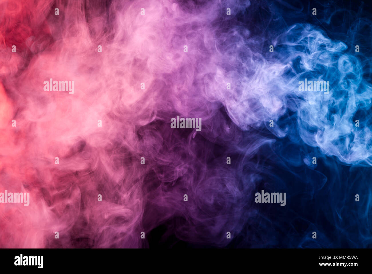 Colorful pink, blue smoke  on a black isolated background. Background from the smoke of vape Stock Photo