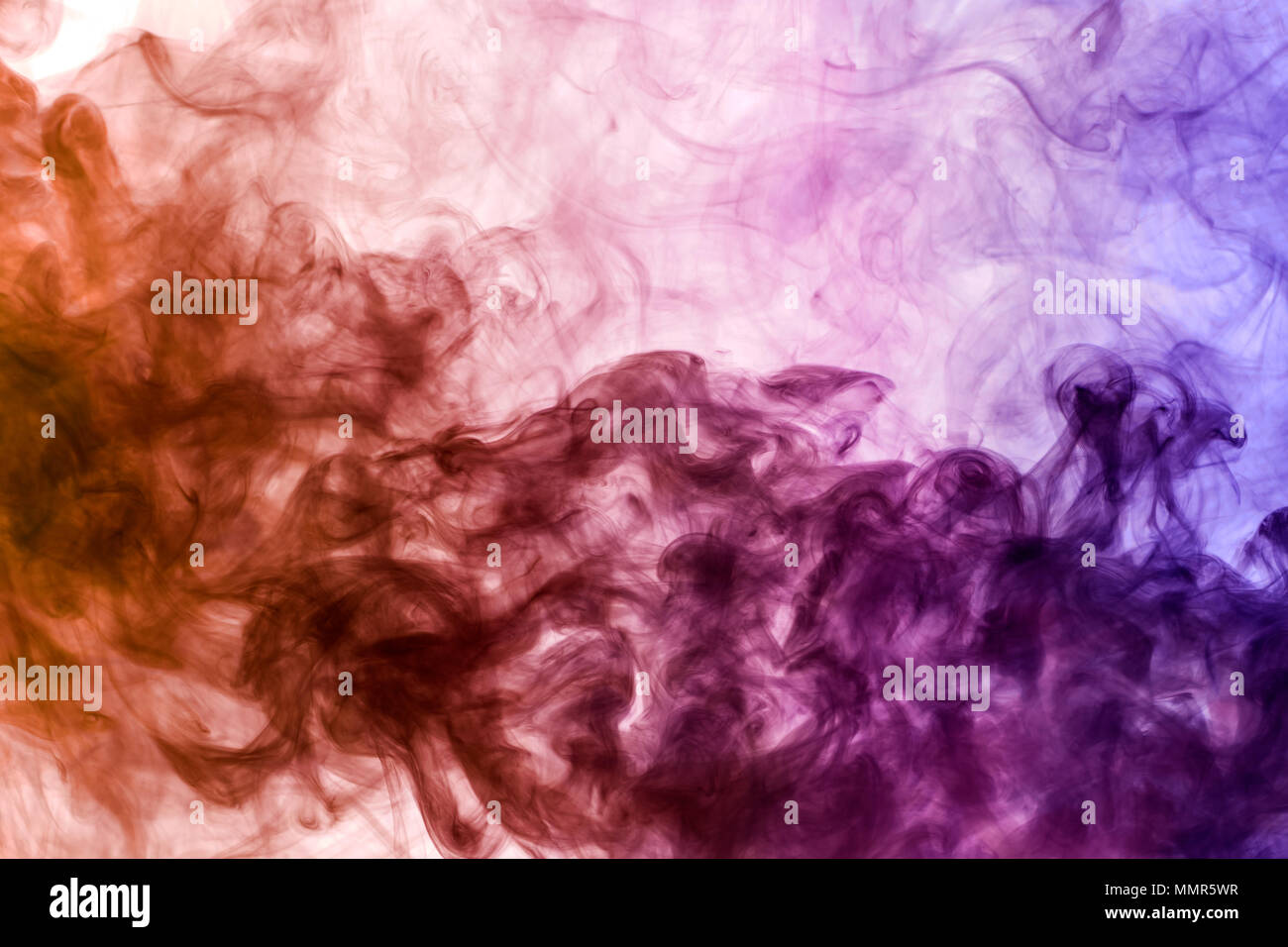 Colorful pink, purple and orange smoke  on a black isolated background. Background from the smoke of vape Stock Photo