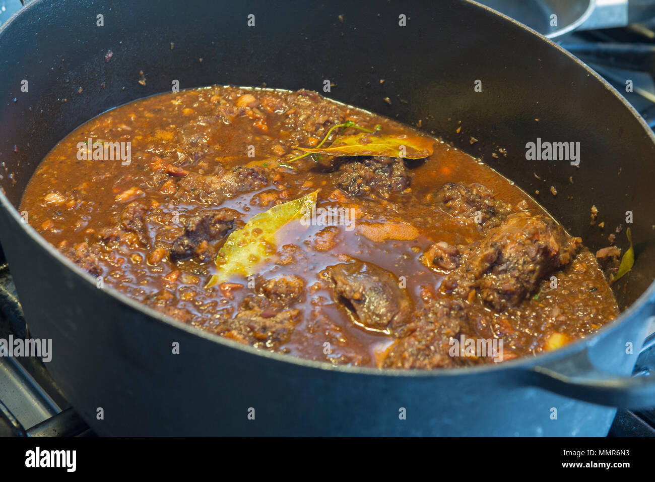Meat stew in sauce in big pan Stock Photo