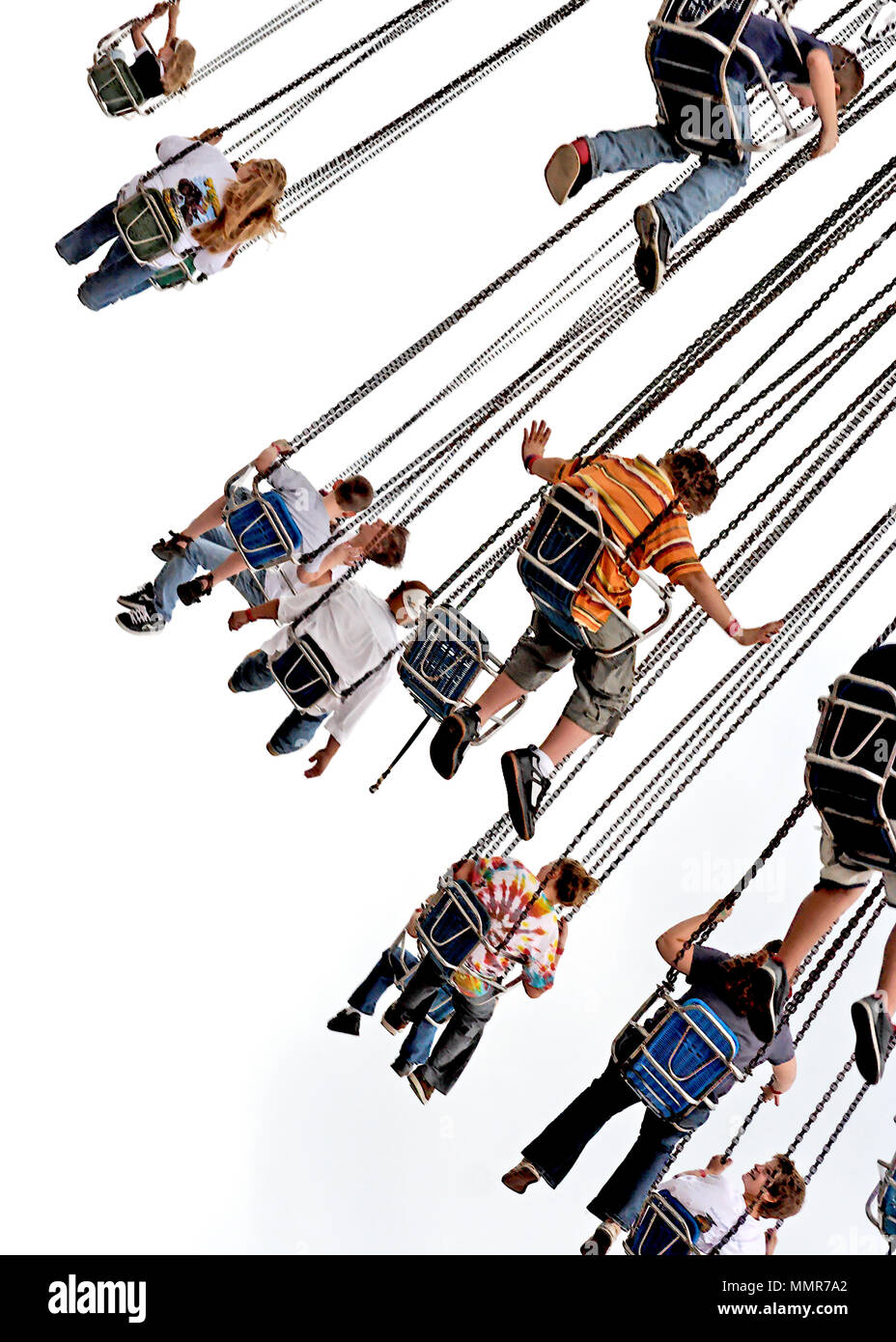 Rear view of children swinging on amusement park swing ride. Focus on boy with arms flying free. Stock Photo