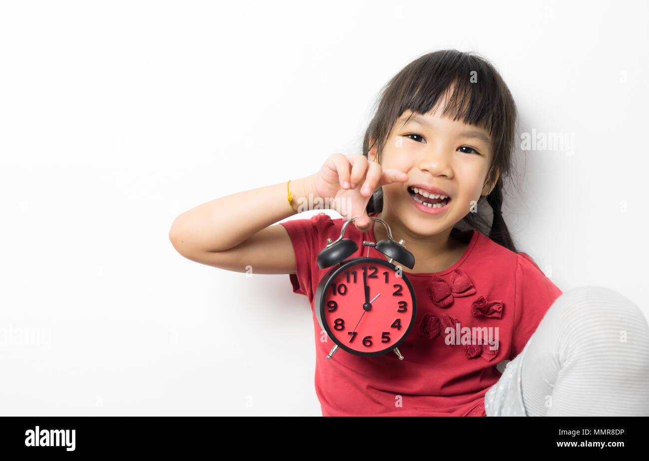 Happy girl is holding alarm clock counting for lunch time Stock Photo