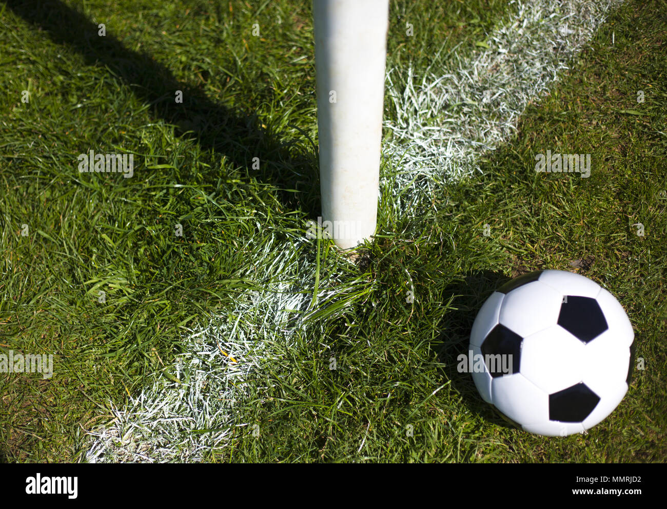 A black and white leather football near a goal post and line Stock Photo